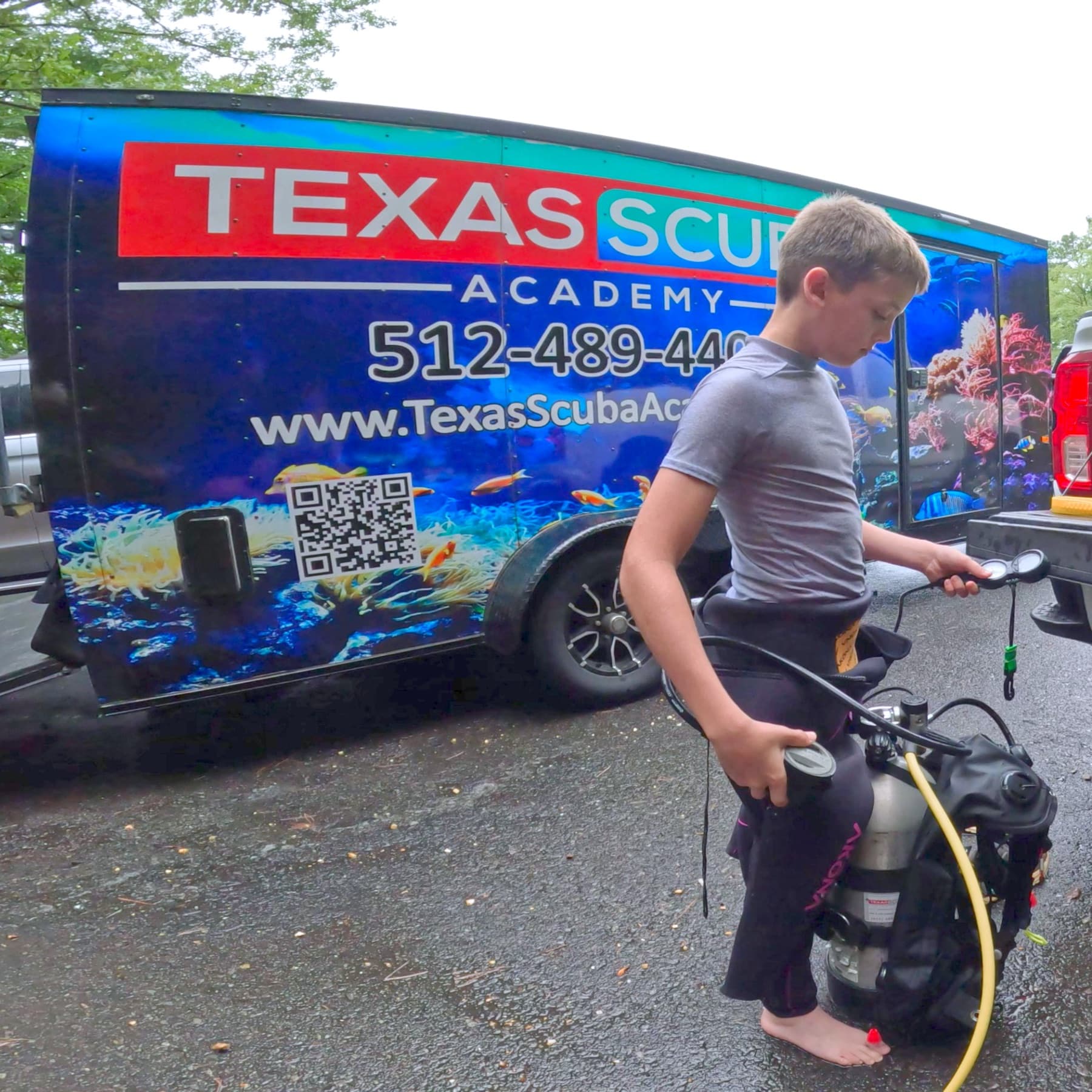 A young diver checking his gauges beside the Texas Scuba Academy trailer